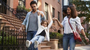 family taking a walk down the street holding hands